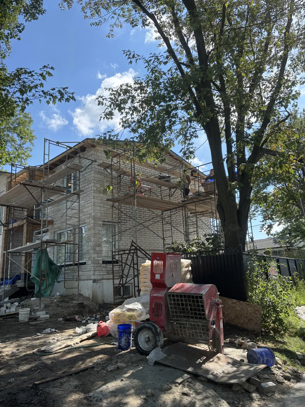 Masonry job site with scaffolding and mixer