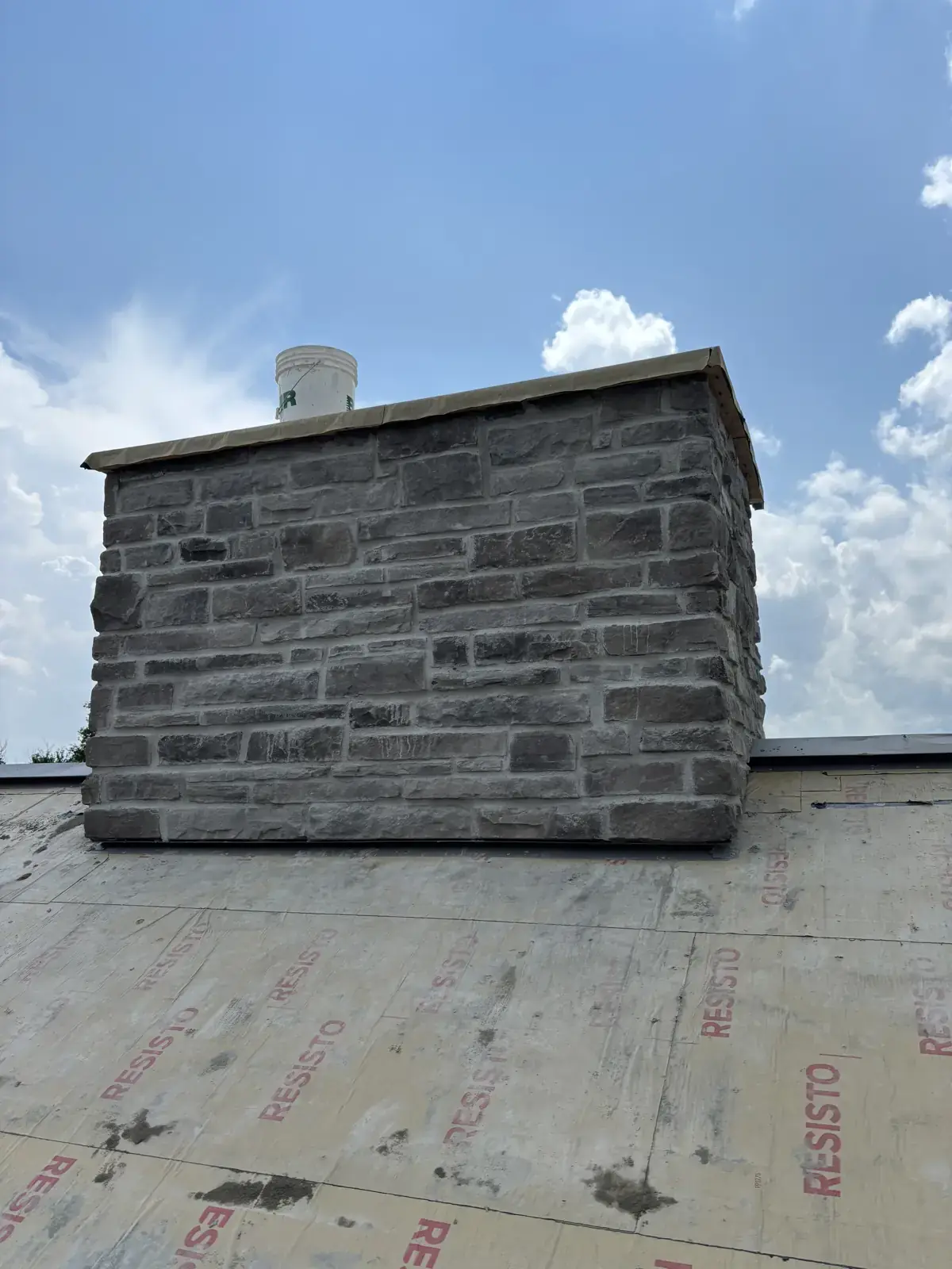Stone chimney rebuilt on a roof