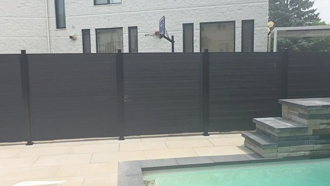 Backyard pool below a wall rebuilt by Maçonnerie Premium